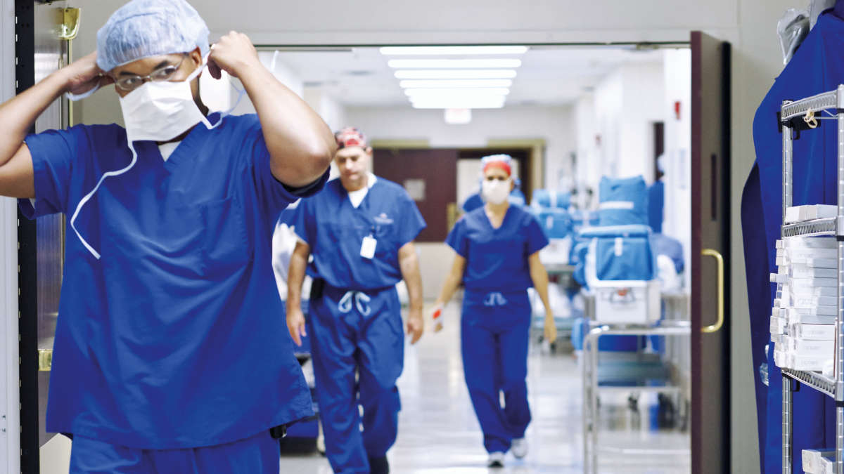 Hospital floor, person with mask and protection suit, walking, unfixing the mask, two more people in the back, 06/2015, (General, Photography, Doctor/Physician, Hospital)